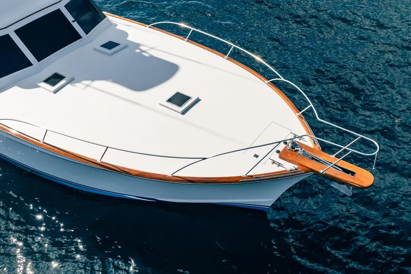 Slide: The Image of 1983 Rybovich 55 Convertible yacht on blue ocean water, showcasing sleek design. - 56