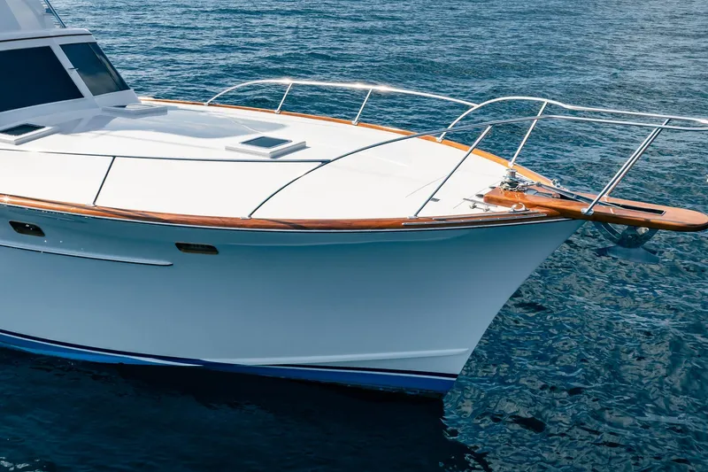 Slide: The Image of 1983 Rybovich 55 Convertible yacht on calm blue water. - 57
