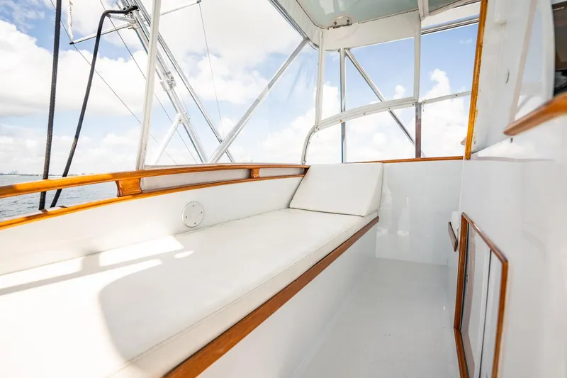 Slide: The Image of 1983 Rybovich 55 Convertible boat interior with white seating and wooden accents. - 58