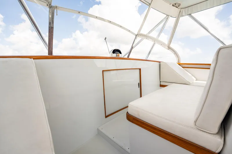 Slide: The Image of 1983 Rybovich 55 Convertible yacht interior with white seating and wooden accents. - 59