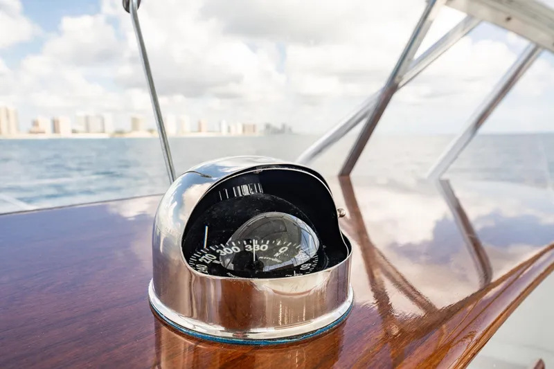 Slide: The Image of Compass on 1983 Rybovich 55 Convertible yacht, with ocean and city skyline in background. - 60