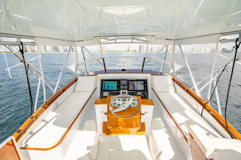Slide: The Image of 1983 Rybovich 55 Convertible yacht helm with ocean view and modern navigation equipment. - 64