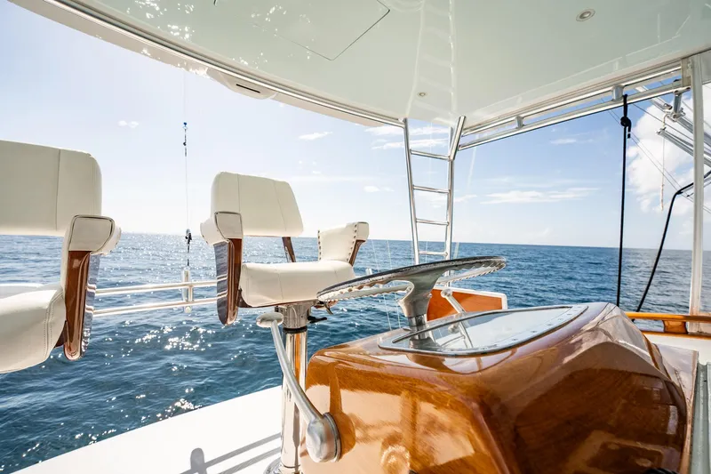 Slide: The Image of 1983 Rybovich 55 Convertible yacht interior with ocean view, featuring helm and seating. - 68