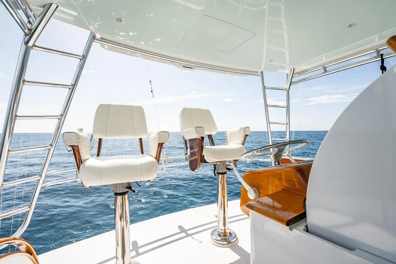 Slide: The Image of 1983 Rybovich 55 Convertible yacht helm with ocean view and white captain chairs. - 71