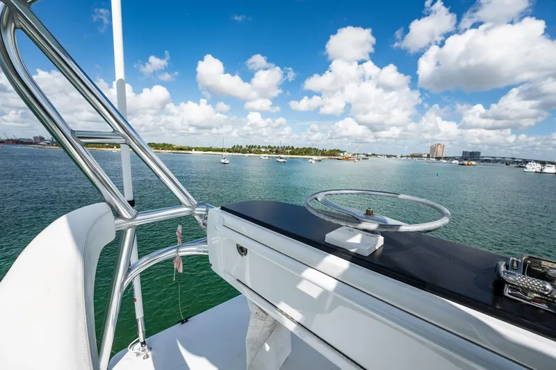 Slide: The Image of 1983 Rybovich 55 Convertible yacht helm with ocean view and blue sky. - 75