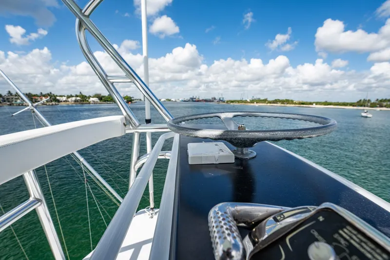 Slide: The Image of 1983 Rybovich 55 Convertible yacht helm with ocean view and blue sky. - 77