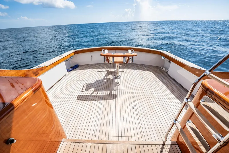 Slide: The Image of 1983 Rybovich 55 Convertible yacht deck with ocean view, featuring polished wood finish. - 86