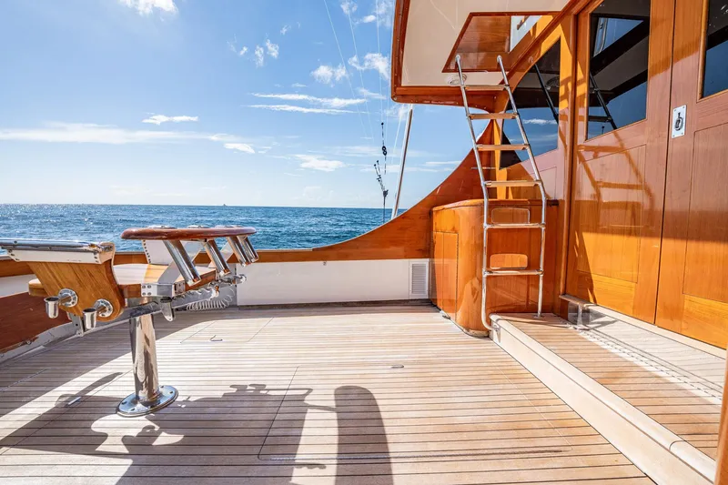 Slide: The Image of 1983 Rybovich 55 Convertible yacht deck with ocean view and wooden finishes. - 87
