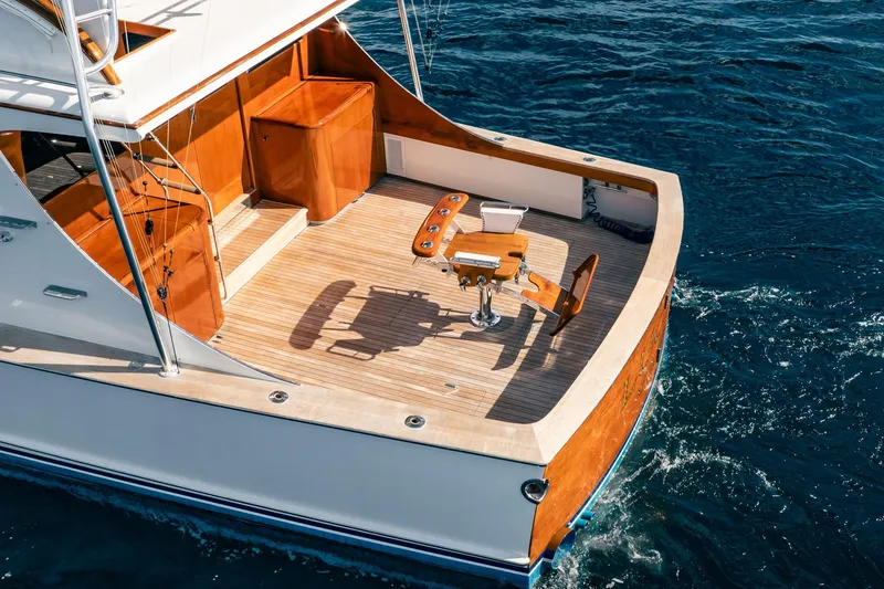 Slide: The Image of 1983 Rybovich 55 Convertible yacht with wooden deck, cruising on blue ocean waters. - 93