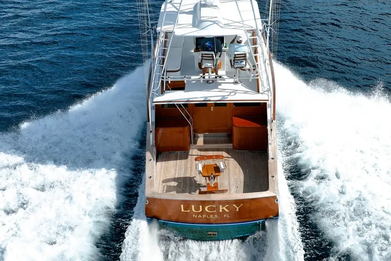 Slide: The Image of 1983 Rybovich 55 Convertible yacht cruising on open water, rear view. - 94