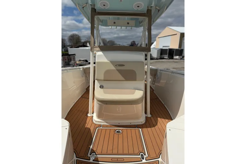 Slide: The Image of 2016 Cobia 277 Center Console boat interior with tan seating and wood-style flooring. - 11