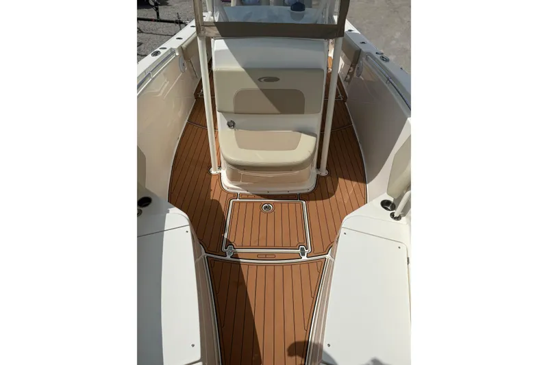 Slide: The Image of 2016 Cobia 277 Center Console boat interior with teak flooring and seating area. - 14
