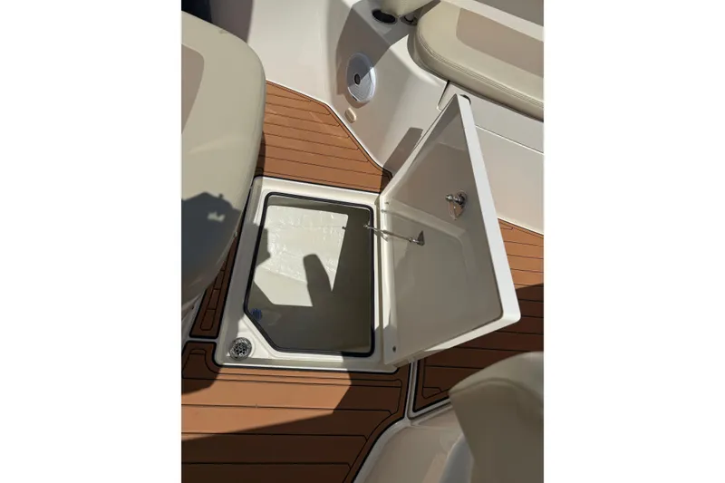 Slide: The Image of Open storage compartment on 2016 Cobia 277 Center Console boat with teak flooring. - 15