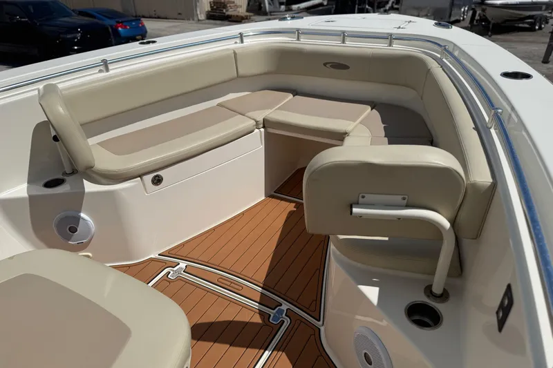 Slide: The Image of 2016 Cobia 277 Center Console boat interior with beige seating and teak-style flooring. - 17