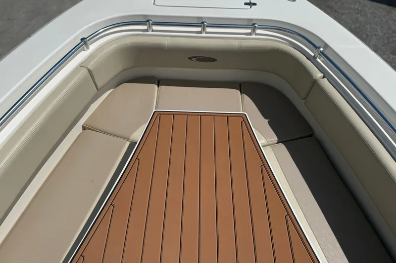 Slide: The Image of 2016 Cobia 277 Center Console boat interior with cushioned seating and wooden deck. - 20