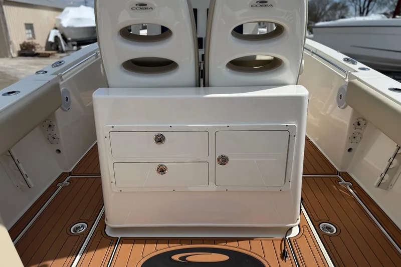 Slide: The Image of 2016 Cobia 277 Center Console boat interior with storage compartments and teak flooring. - 22