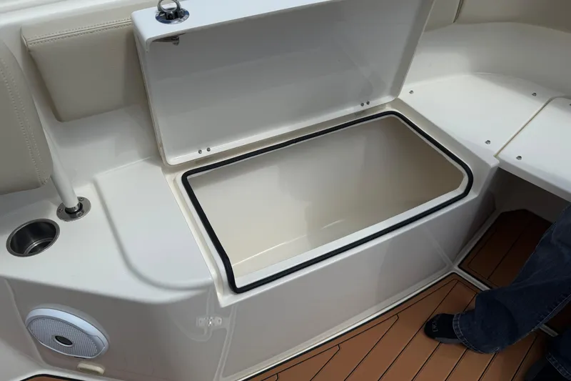 Slide: The Image of Open storage compartment on 2016 Cobia 277 Center Console boat, featuring teak flooring. - 27