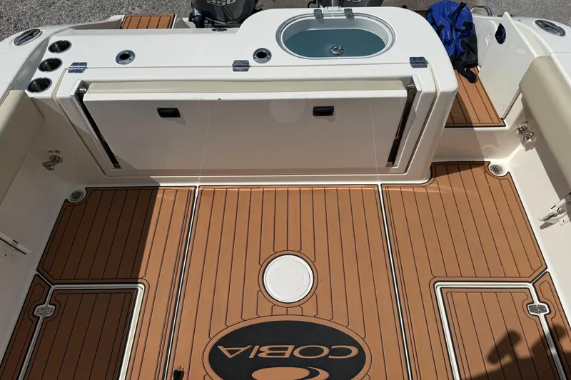 Slide: The Image of 2016 Cobia 277 Center Console boat deck with teak flooring and livewell. - 28