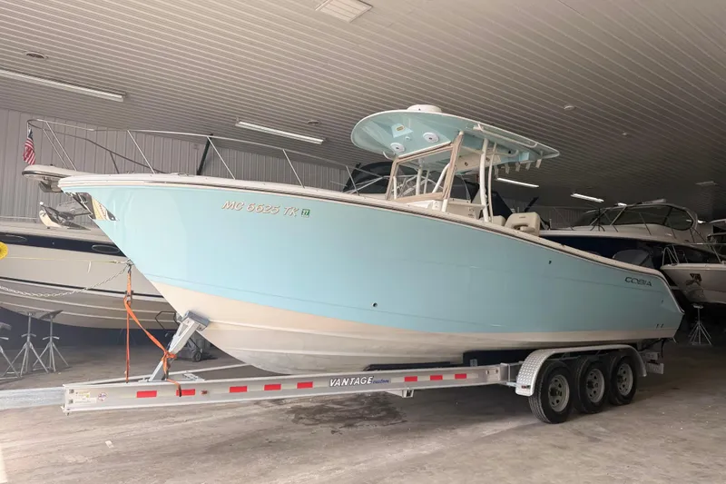Slide: The Image of 2016 Cobia 277 Center Console boat on trailer in indoor storage. - 3