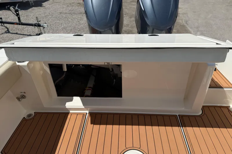Slide: The Image of 2016 Cobia 277 Center Console boat with open storage compartment and twin engines. - 33
