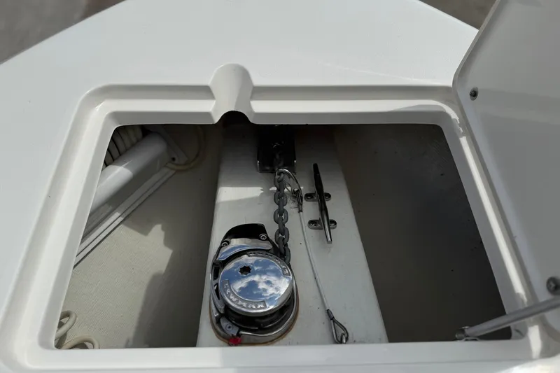 Slide: The Image of Anchor compartment of 2016 Cobia 277 Center Console boat, featuring chain and winch. - 34