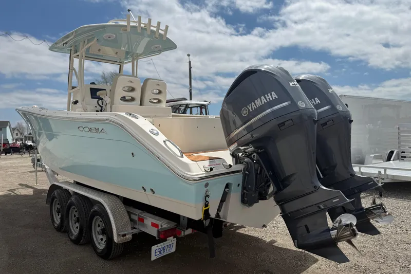 Slide: The Image of 2016 Cobia 277 Center Console boat with dual Yamaha engines on a trailer. - 35