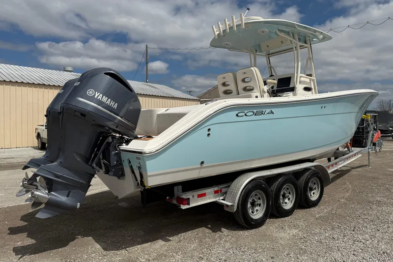 Slide: The Image of 2016 Cobia 277 Center Console boat on trailer with Yamaha engine, parked outdoors. - 36