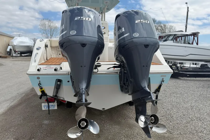 Slide: The Image of 2016 Cobia 277 Center Console boat with dual Yamaha 250 engines, parked outdoors. - 37