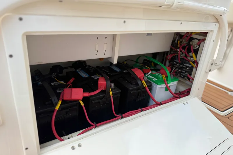 Slide: The Image of Battery compartment of a 2016 Cobia 277 Center Console boat with wiring connections. - 42