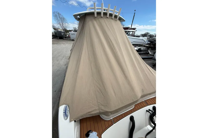 Slide: The Image of 2016 Cobia 277 Center Console boat with protective cover in a marina setting. - 47