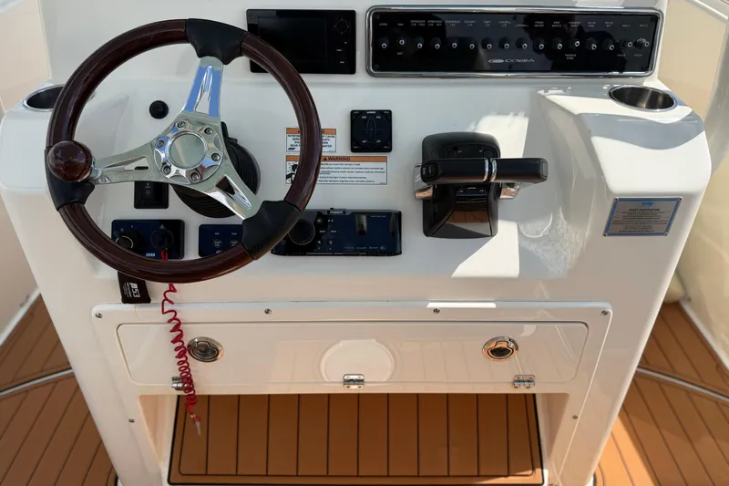 Slide: The Image of 2016 Cobia 277 Center Console helm with steering wheel and control panel. - 5