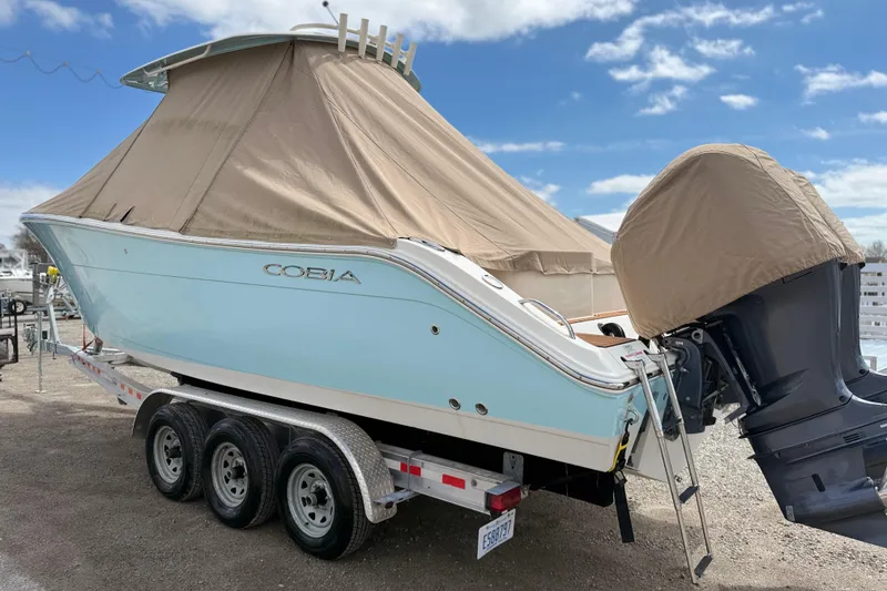 Slide: The Image of 2016 Cobia 277 Center Console boat on trailer, covered, with outboard motor. - 50