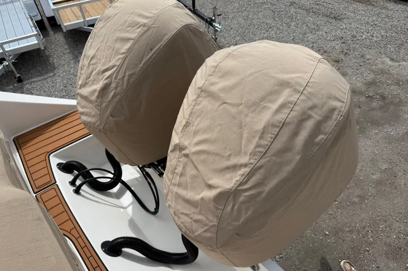 Slide: The Image of Covered engines on a 2016 Cobia 277 Center Console boat, with tan protective covers. - 51