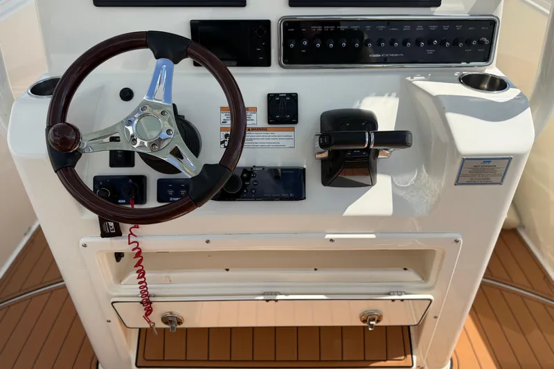 Slide: The Image of 2016 Cobia 277 Center Console helm with steering wheel and control panel. - 6