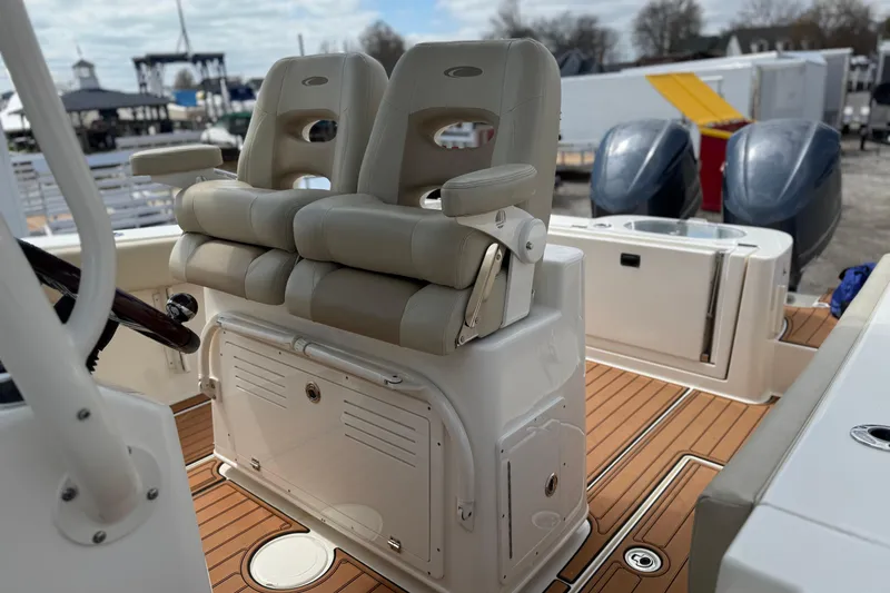 Slide: The Image of 2016 Cobia 277 Center Console boat interior with dual seats and teak flooring. - 8