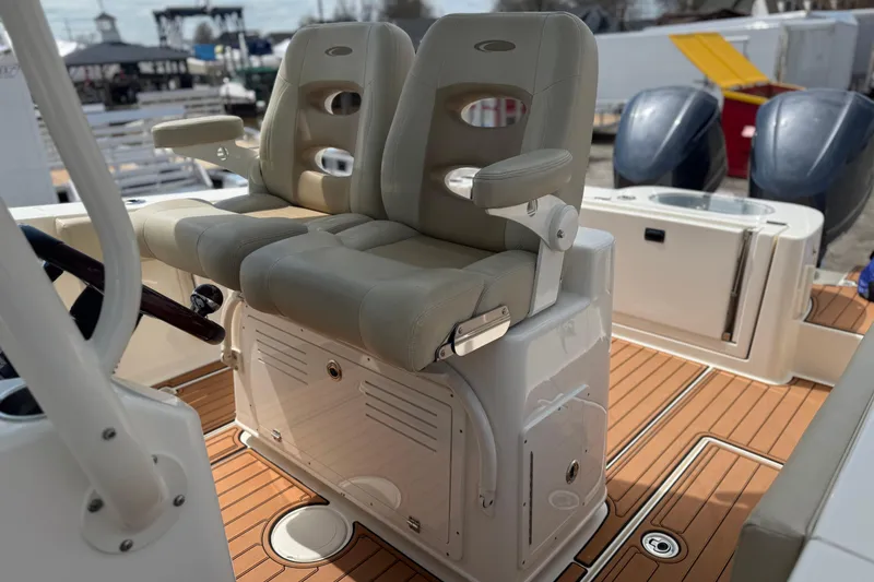 Slide: The Image of 2016 Cobia 277 Center Console boat with dual cushioned seats and teak flooring. - 9