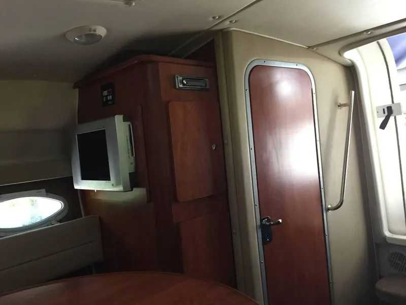Slide: The Image of Interior of 2006 Rinker 270 Express Cruiser with wood doors and TV. - 12