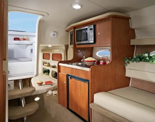 Slide: The Image of Interior of 2006 Rinker 270 Express Cruiser with kitchen and seating area. - 17
