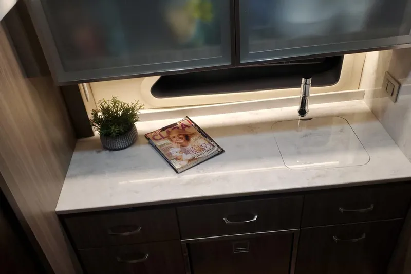 Slide: The Image of Modern kitchen area in 2022 Regal 42 XO yacht with magazine and plant. - 12