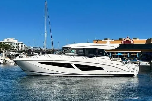 Slide: The Image of 2022 Regal 42 XO yacht docked in a marina under clear blue skies. - 3