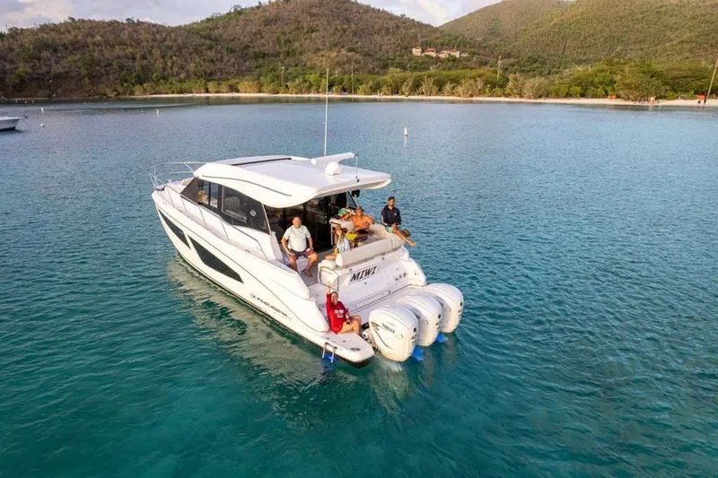 Slide: The Image of 2022 Regal 42 XO yacht on serene blue waters with passengers enjoying the view. - 4