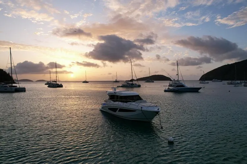 Slide: The Image of Sunset over a serene bay with a 2022 Regal 42 XO yacht anchored. - 8