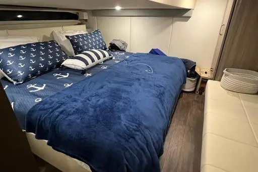Slide: The Image of Luxurious 2022 Regal 42 XO yacht cabin with nautical-themed bedding and modern decor. - 9