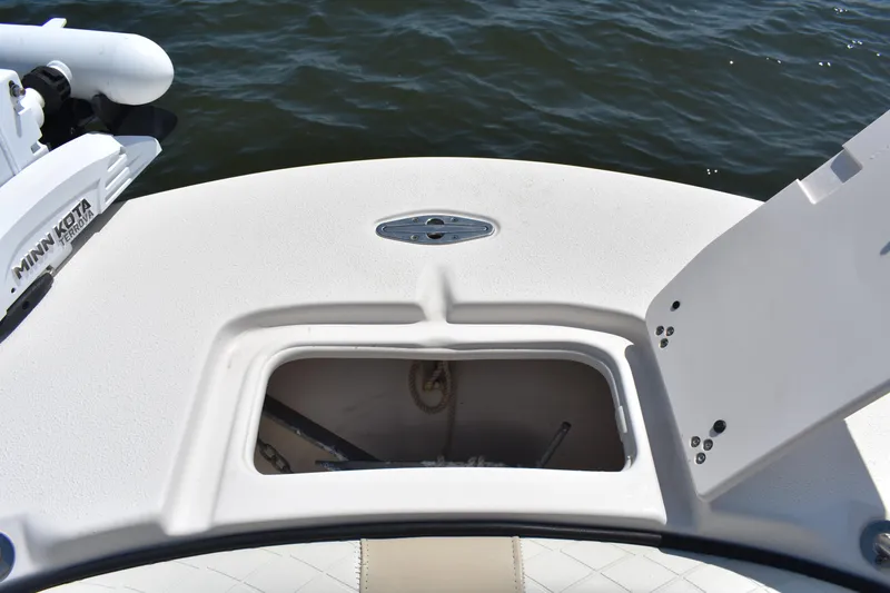 Slide: The Image of 2022 Carolina Skiff 21 Ultra Elite boat with open storage compartment and Minn Kota motor. - 11