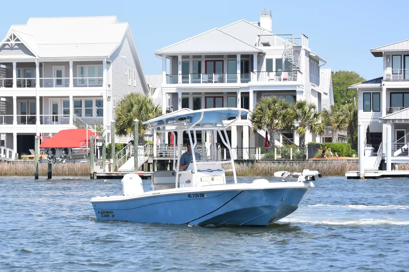 Slide: The Image of 2022 Carolina Skiff 21 Ultra Elite boat cruising near waterfront homes. - 3