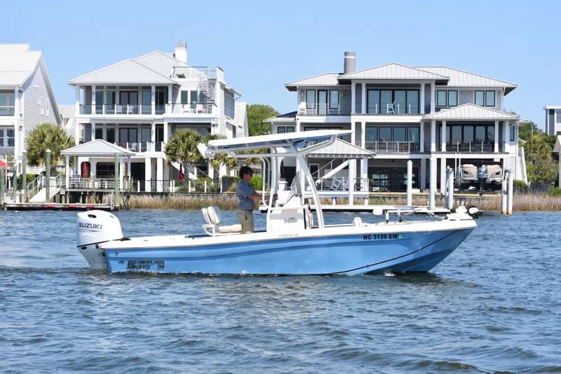 Slide: The Image of 2022 Carolina Skiff 21 Ultra Elite boat cruising near waterfront homes. - 4