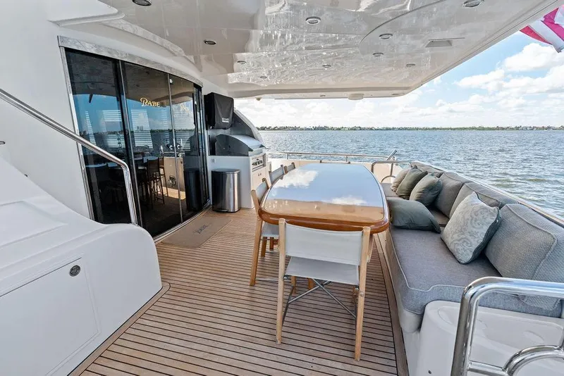 Slide: The Image of Luxurious Horizon 82 yacht deck with dining area, cushions, and ocean view, 2005 model. - 10