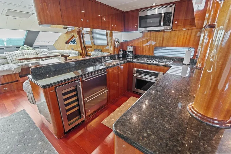 Slide: The Image of Luxurious yacht kitchen with wood cabinetry, granite countertops, and modern appliances on a 2005 Horizon 82. - 32