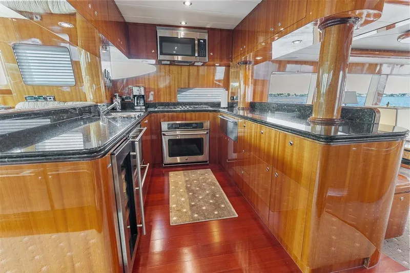 Slide: The Image of Luxurious yacht kitchen with wooden cabinetry, granite countertops, and modern appliances on a 2005 Horizon 82. - 33