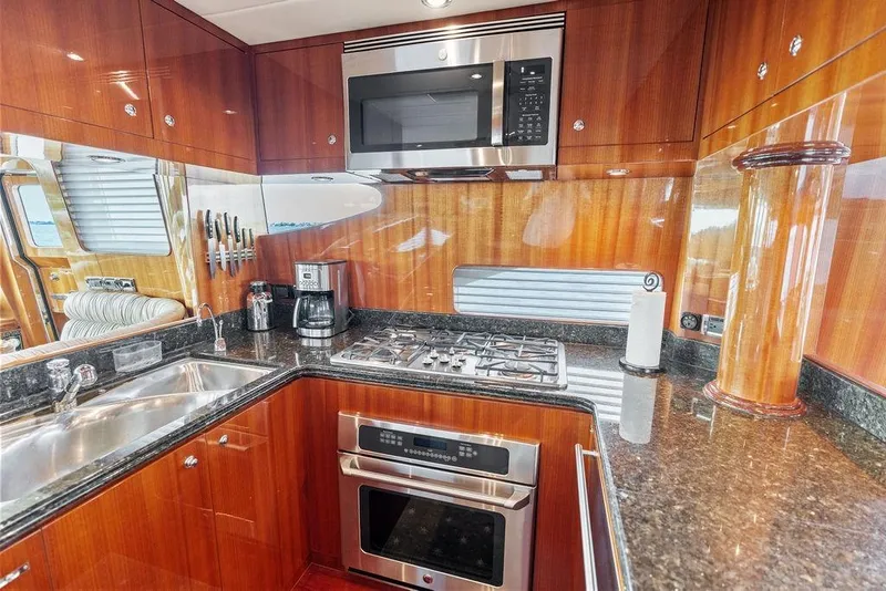 Slide: The Image of Luxurious 2005 Horizon 82 yacht kitchen with modern appliances and elegant wood finish. - 34